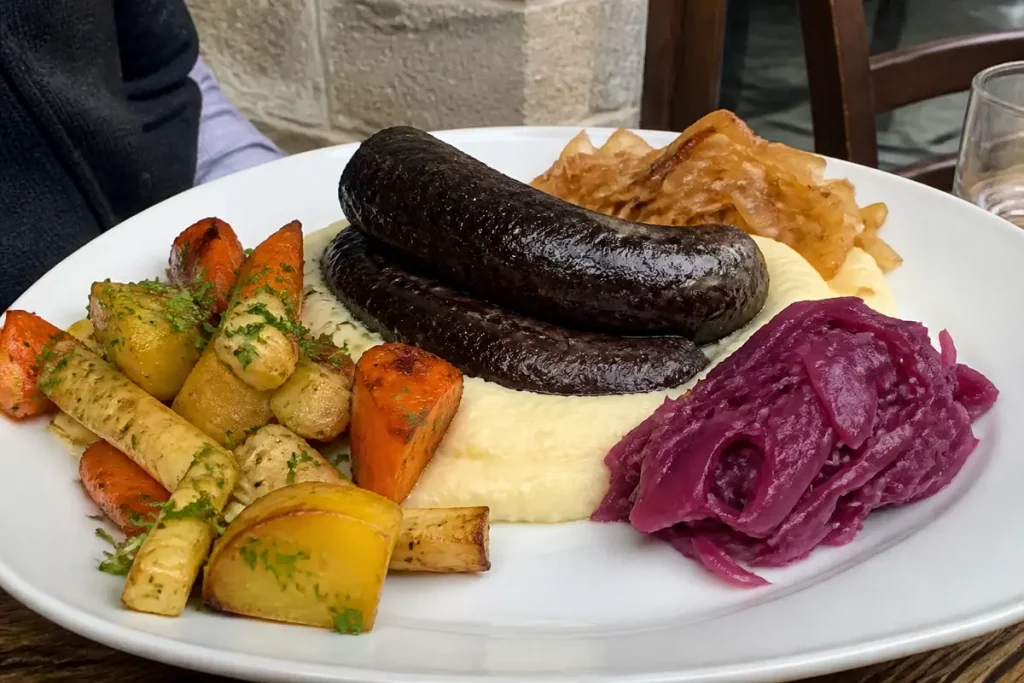 Assiette gourmande de légumes rÎtis en accompagnement du boudin noir avec purée et choux