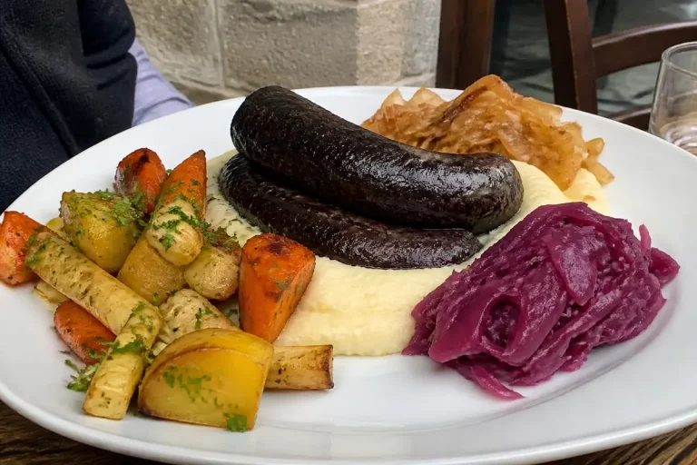 Assiette gourmande de légumes rôtis en accompagnement du boudin noir avec purée et choux